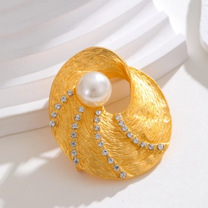 Spilla vintage dorata geometrica con perla centrale e strass su sfondo bianco
