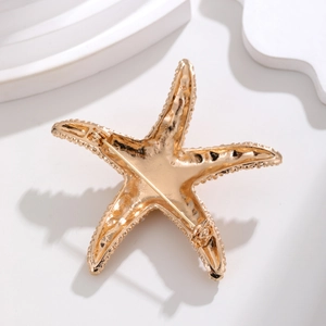 Eleganter Seestern-Anstecker in Gold mit Detailansicht der Nadel auf der Rückseite