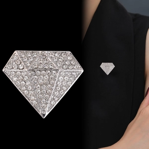 Macro detail of silver alloy diamond-shaped brooch with sparkling rhinestone pavé setting