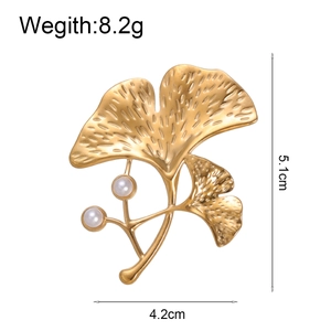 Broche élégante en forme de feuille de ginkgo dorée avec perles blanches sur fond blanc pur