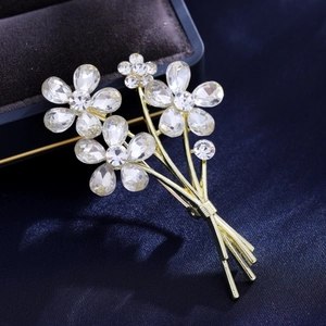 Broche bouquet de fleurs dorées luxe avec cristaux sur boîte de velours bleu élégant
