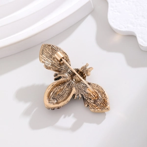 Vintage gold bee brooch shown from the back featuring a secure safety pin fastener