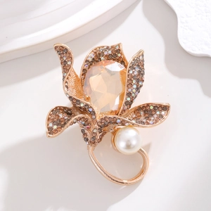 Detailed macro view of vintage flower brooch with amber crystal petals and white pearl accent