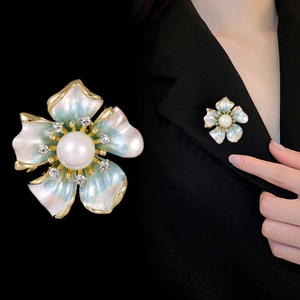 Détail de la broche fleur en émail bleu avec perle centrale et accents de cristal