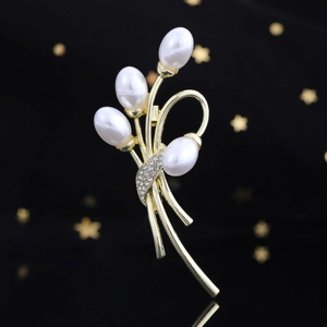 Elegante spilla a bouquet di perle con stelo dorato e zirconi su sfondo nero