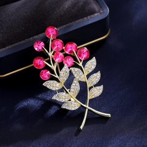 Broche fleur dorée élégante avec baies en cristal rouge et feuilles serties de pavé blanc