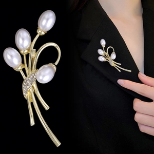 Elegante spilla a tulipano dorata con perle e zirconi su una giacca blazer nera