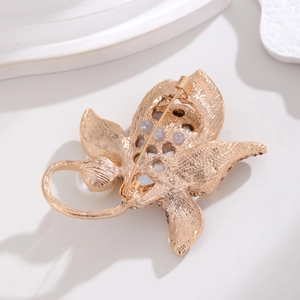 Elegant gold butterfly brooch with pearl and rhinestones shown from a back side angle