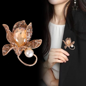 Vintage orchid flower brooch with amber crystal and pearl shown on a black blazer
