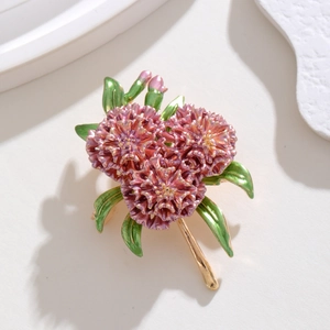 Macro shot of hydrangea brooch showing pink enamel petals and gold leaf details
