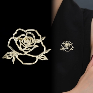 Elegant gold hollow rose brooch with leaf accents shown on black suit and studio view