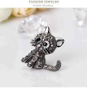 Detailed view of cat brooch with dark grey rhinestones and black gem eyes on silver base
