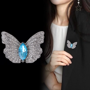 Schmetterlingsbrosche mit weißen Strasssteinen und blauem Marquise-Kristall auf Schwarz