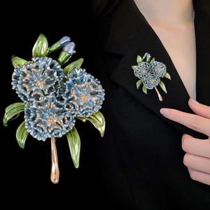 Detail of blue hydrangea brooch on blazer showing enamel texture and gold-plated stems