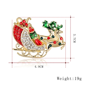 Golden Christmas reindeer sleigh brooch with festive red and green rhinestones