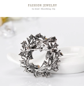 Detail view of the vintage silver metal back pin and texture of the Christmas wreath brooch