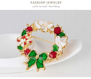 Detaillierte Nahaufnahme einer Weihnachtskranz-Brosche mit Emaille-Blumen und Taube