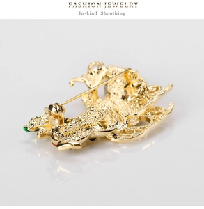 Detail view of gold Christmas brooch back showing alloy texture and pin clasp mechanism
