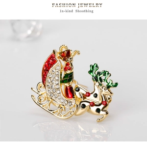 Macro detail of Christmas sleigh brooch with sparkling red and green crystals