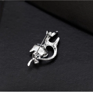 Broche chat en argent avec cristal bleu foncé sur une boîte de présentation noire