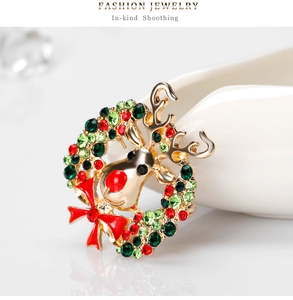 Detail of Christmas reindeer brooch with red bow and colorful rhinestones on white base
