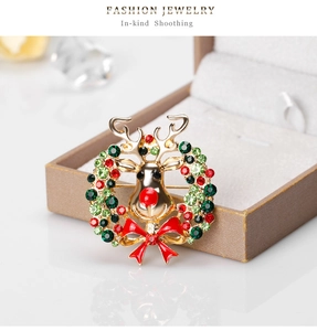 Detail of Christmas reindeer brooch with red enamel bow and crystal wreath