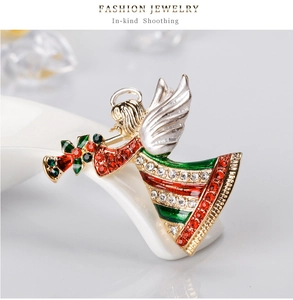 Gros plan sur la broche ange dorée avec strass colorés et détails en émail vert