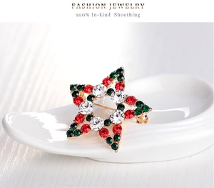 Gros plan d'une broche de Noël en forme d'étoile avec strass rouges et verts brillants