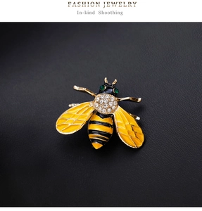 Macro shot of bee brooch with yellow enamel wings and sparkling crystal accents