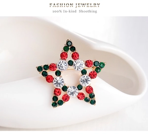 Détail macro d'une broche de Noël en forme d'étoile avec strass rouges et verts sur métal doré