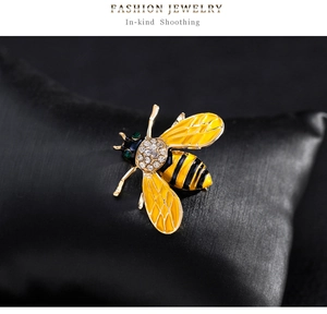 Close-up of a bee brooch with yellow enamel wings and sparkling inlaid rhinestones