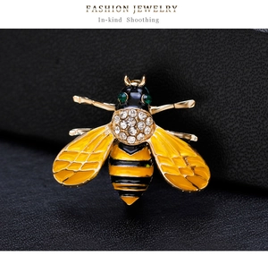 Close-up of a bee brooch with yellow and black enamel, sparkling crystals on black leather