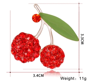 Detailed view of cherry brooch with red rhinestones and green enamel 3.3x3.4cm size