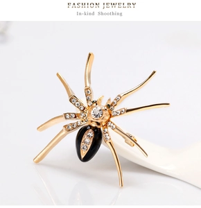 Macro detail van gouden spinnenbroche met kristallen strass en groene edelsteenogen