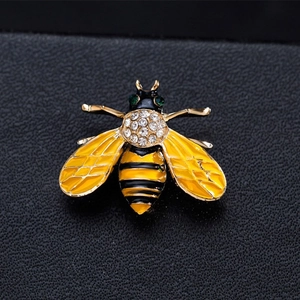 Exquisite bee brooch with yellow enamel and sparkling rhinestones on black leather background