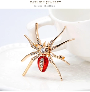 Macro-opname van spinnenbroche met goudlegering poten en sprankelende witte strass