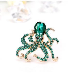 Elegant gold-tone octopus brooch featuring green crystal drops and shimmering zircons
