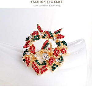 Macro shot of Christmas wreath brooch with colorful rhinestones and gold bell detail