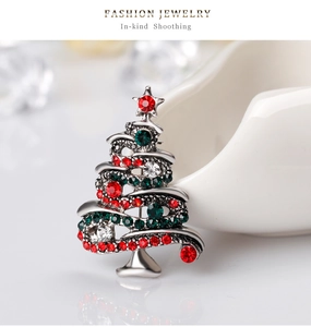 Macro shot of silver alloy Christmas tree brooch with red and green rhinestones detail