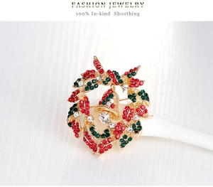 Detailed view of luxury Christmas wreath brooch with colorful rhinestones and gold bell