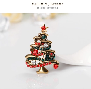 Detailed macro view of vintage gold Christmas tree brooch with colorful rhinestones