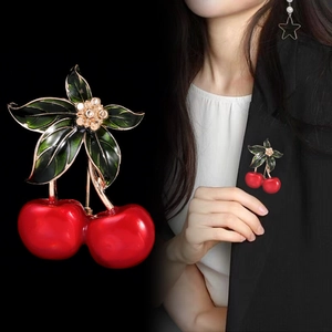 Gros plan et vue mannequin d'une broche cerise rouge avec détails fleur en cristal