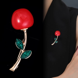 Close-up of cherry brooch with red glossy fruits and green faceted crystal leaves