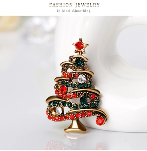 Detailed view of a vintage Christmas tree brooch with colorful rhinestones on a stand