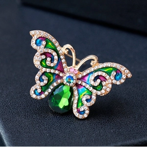 Elegante spilla a farfalla con smalto colorato e gemma verde su pelle nera