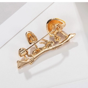 Golden alloy brooch featuring mushroom and rabbit silhouettes with hammer texture back