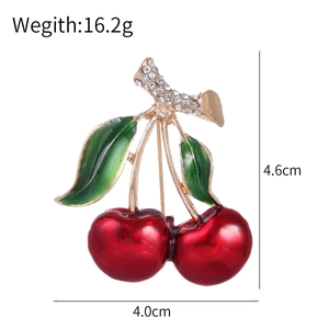 Broche cerise tendance avec émail rouge, feuilles vertes et strass sur base dorée
