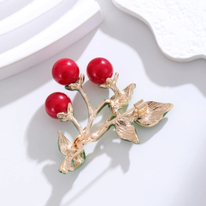 Elegant cherry brooch with red pearl berries and gold metal leaves on a stone base