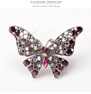 Vista macro della spilla a farfalla vintage in argento con cristalli rossi e strass AB