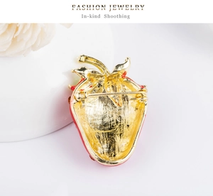 Macro detail of gold-plated strawberry brooch back with secure pin clasp mechanism